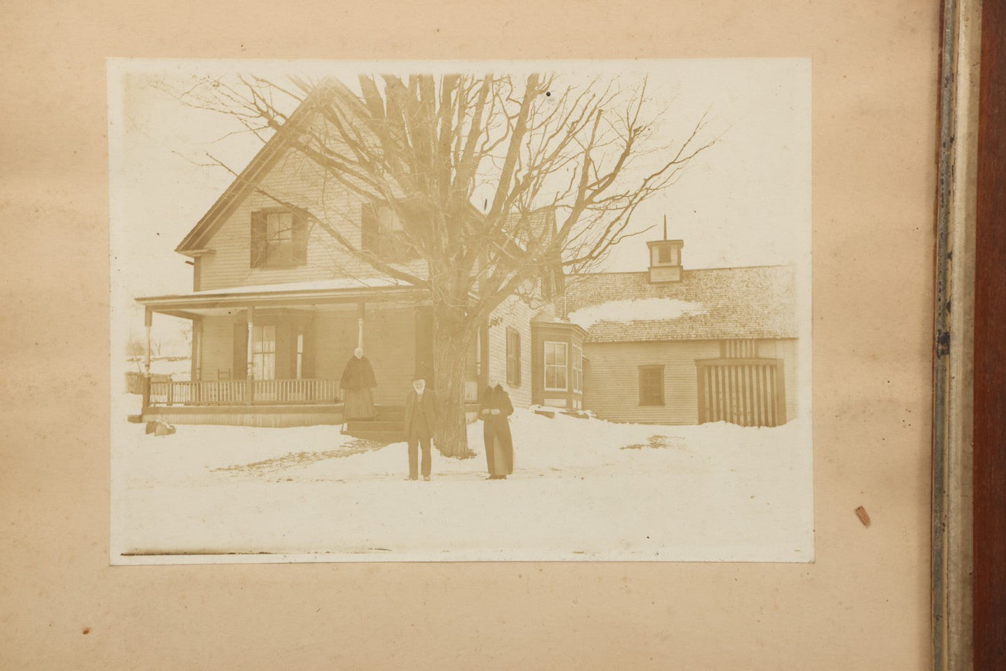 Lot 111 - Antique Boarded Photograph Of Elderly Couple And Older Woman Before New England Connected Farmhouse And Barn In Winter, In Walnut Double Frame, 13-1/4" x 11-3/8"