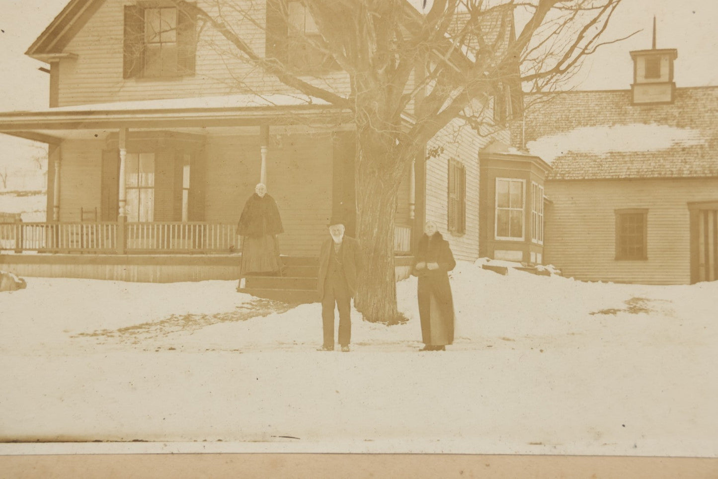 Lot 111 - Antique Boarded Photograph Of Elderly Couple And Older Woman Before New England Connected Farmhouse And Barn In Winter, In Walnut Double Frame, 13-1/4" x 11-3/8"