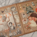 Lot 134 - Antique Linen Scrapbook With Fabric Pages Containing Over 100 Hand Cut Magazine Clippings Including Santa, Children, Animals, Kewpies, Women, Advertisements, And More Circa 1913