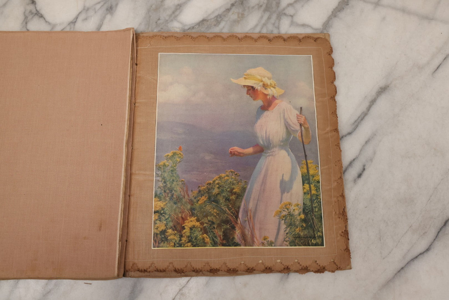 Lot 134 - Antique Linen Scrapbook With Fabric Pages Containing Over 100 Hand Cut Magazine Clippings Including Santa, Children, Animals, Kewpies, Women, Advertisements, And More Circa 1913