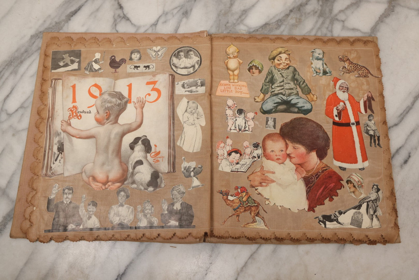 Lot 134 - Antique Linen Scrapbook With Fabric Pages Containing Over 100 Hand Cut Magazine Clippings Including Santa, Children, Animals, Kewpies, Women, Advertisements, And More Circa 1913