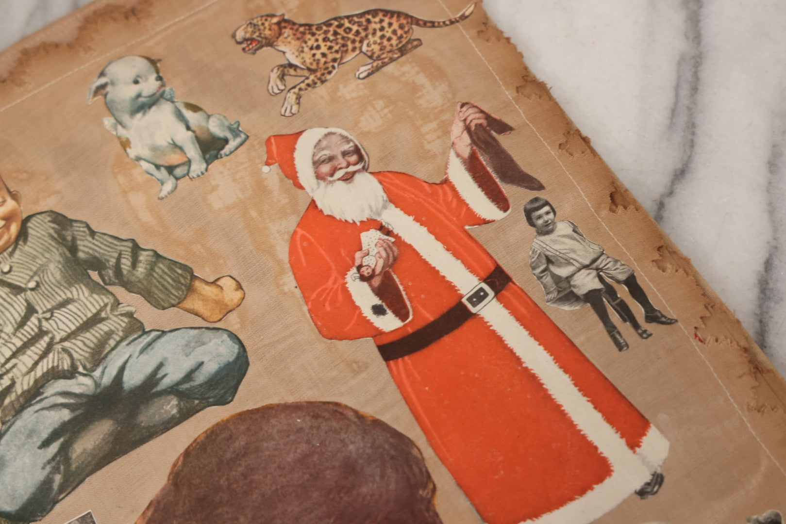 Lot 134 - Antique Linen Scrapbook With Fabric Pages Containing Over 100 Hand Cut Magazine Clippings Including Santa, Children, Animals, Kewpies, Women, Advertisements, And More Circa 1913