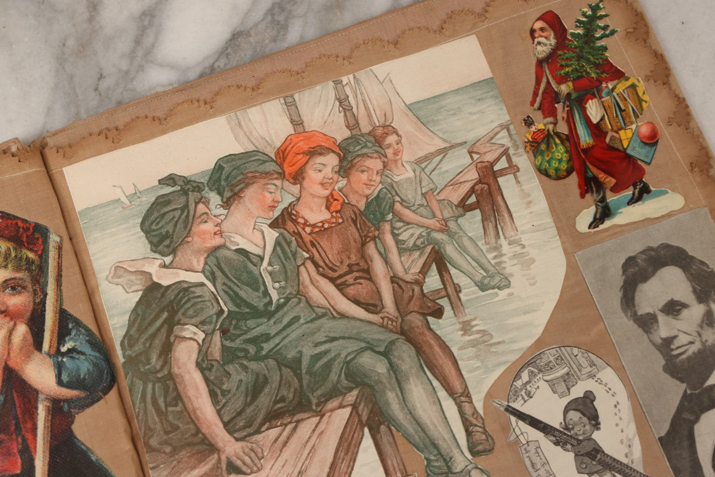 Lot 134 - Antique Linen Scrapbook With Fabric Pages Containing Over 100 Hand Cut Magazine Clippings Including Santa, Children, Animals, Kewpies, Women, Advertisements, And More Circa 1913