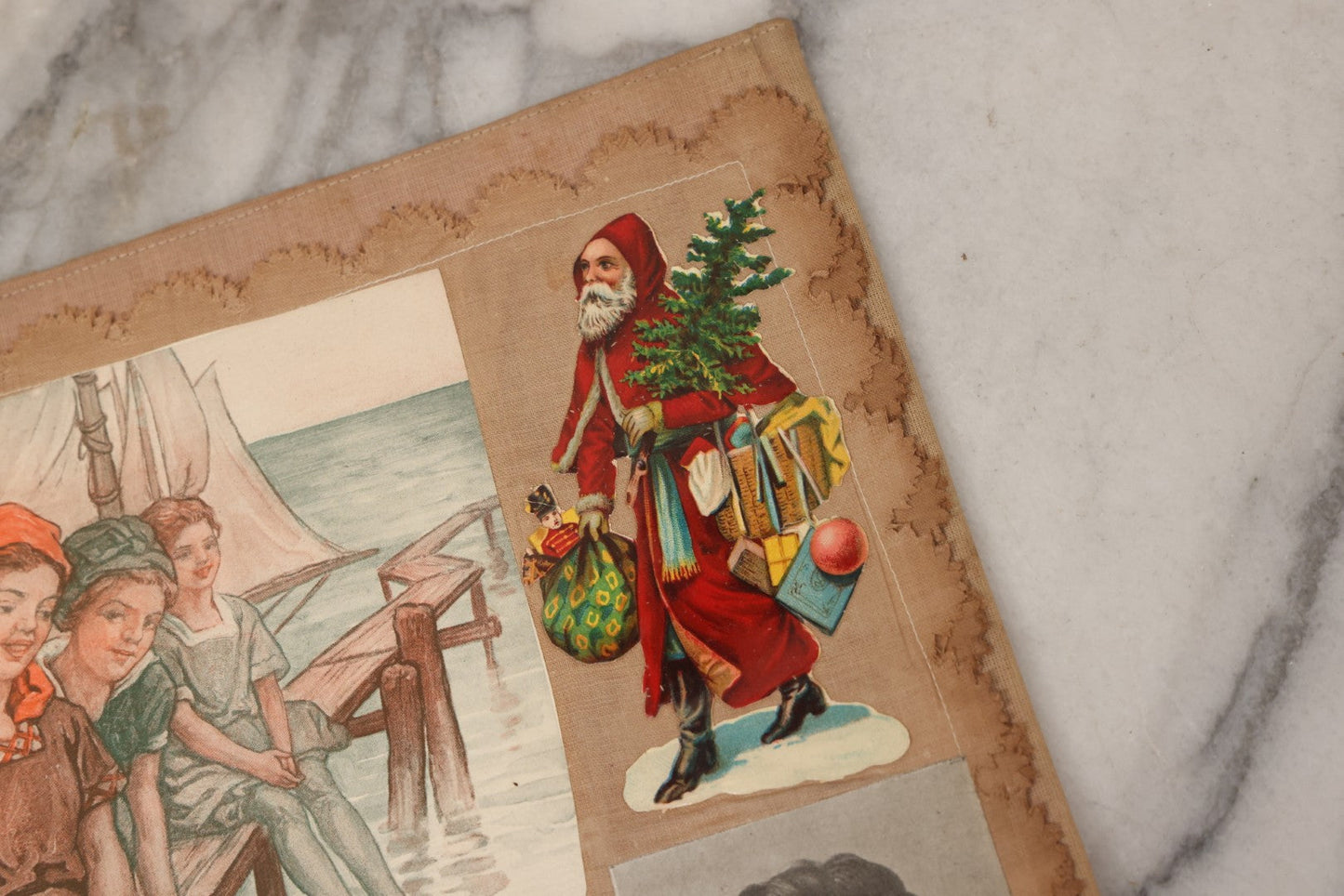 Lot 134 - Antique Linen Scrapbook With Fabric Pages Containing Over 100 Hand Cut Magazine Clippings Including Santa, Children, Animals, Kewpies, Women, Advertisements, And More Circa 1913