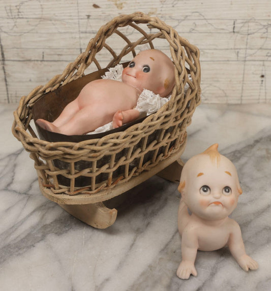 Lot 150 - Pair Of Antique Bisque Kewpie Dolls, One In Wicker Rocking Crib With Lace Bedding