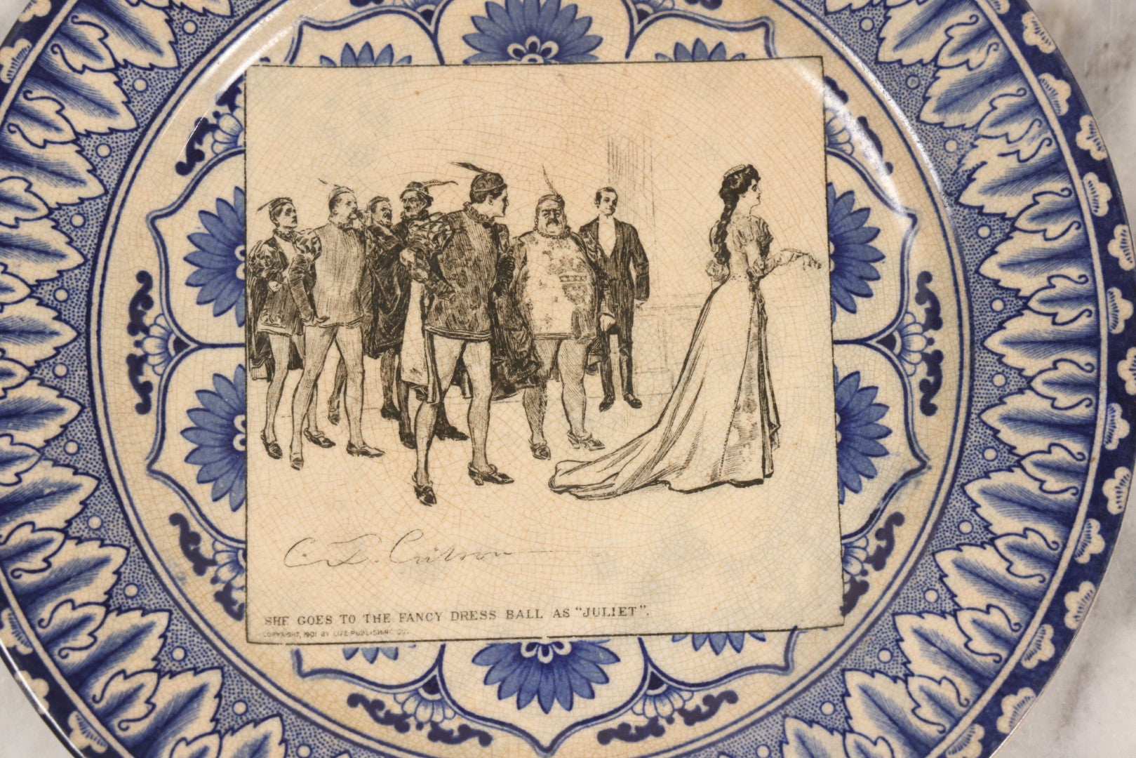 Lot 153 - Pair Of Antique Royal Doulton Decorative Plates With Life Publishing Co. Scenes By Charles Dana Gibson, 1900–1901, Including "They Go Fishing" And "She Goes To The Fancy Dress Ball As 'Juliet'," 10-1/2" Diameter Each