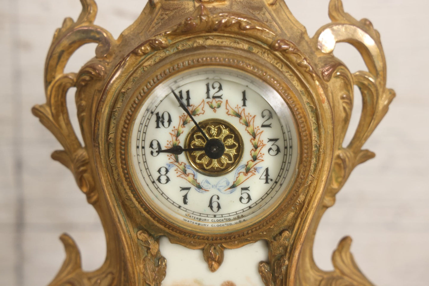 Lot 012 - Antique Waterbury Clock Co. Gold-Painted Spelter Mantel Clock With Hand-Painted Dial And Cupid Scene Panel, Circa 1890s Working Condition, 11" H