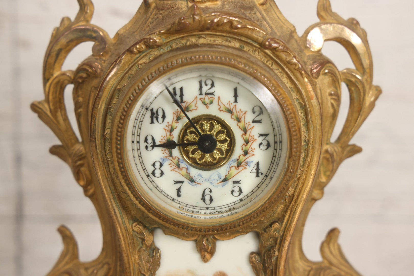 Lot 012 - Antique Waterbury Clock Co. Gold-Painted Spelter Mantel Clock With Hand-Painted Dial And Cupid Scene Panel, Circa 1890s Working Condition, 11" H
