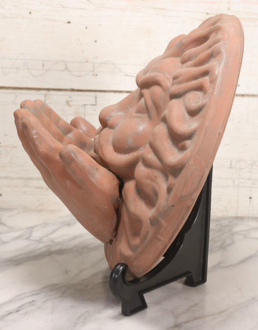 Lot 020 - Vintage Unglazed Ceramic Greenman Wall Plaque With Relief Face Blowing Over Pair Of Hands, Cold-Painted Surface, Marked "B P" On Verso, 13-3/4" Diameter