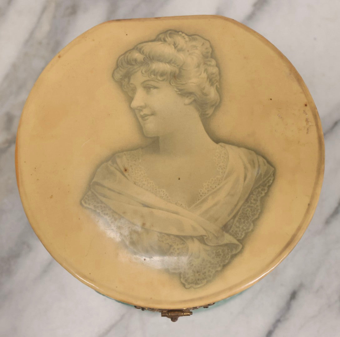 Lot 028 - Antique Blue-Green And White Celluloid Collar Box With Printed Portrait Of Woman, Pink Fabric Lining, And Arrow Cluett Peabody & Co. Collar, 6" H
