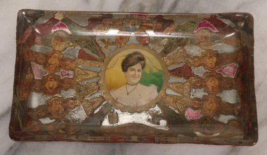Lot 031 - Antique Reverse Painted And Collaged Cigar Bands Glass Tray With Portrait Of Woman And Red Felt Backing, 8-7/8" x 5"