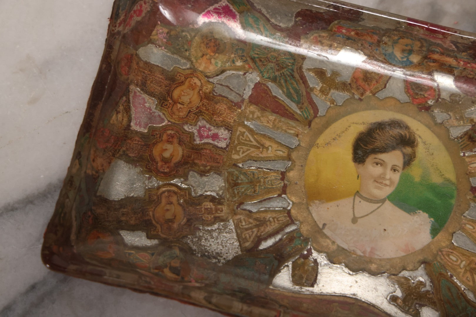 Lot 031 - Antique Reverse Painted And Collaged Cigar Bands Glass Tray With Portrait Of Woman And Red Felt Backing, 8-7/8" x 5"