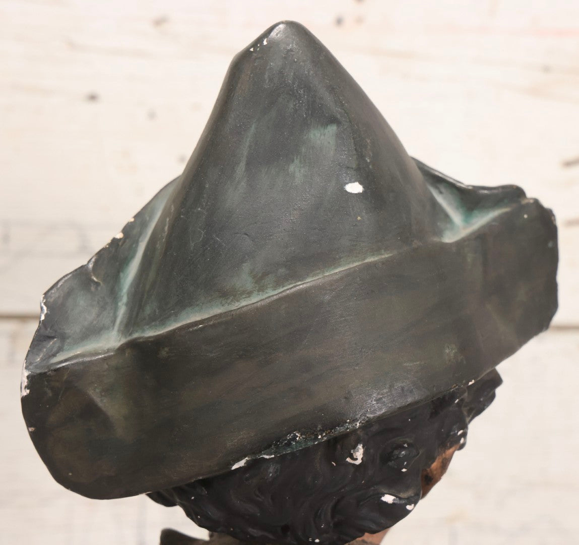 Lot 032 - Antique Hand Painted Chalkware Bust Of Boy In Green Ruffle Collared Shirt And Folded Paper Style Hat With Black Band And Green Top, 15" H