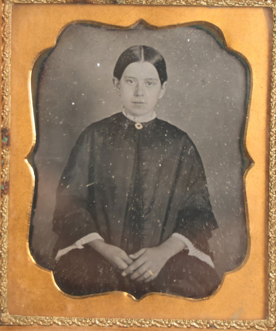 Lot 043 - Antique 1/6th Plate Daguerreotype Photograph Of Young Married Woman With Hand-Painted Gold Jewelry, In Full Split Leatherette Union Case With Embossed Bouquet Design