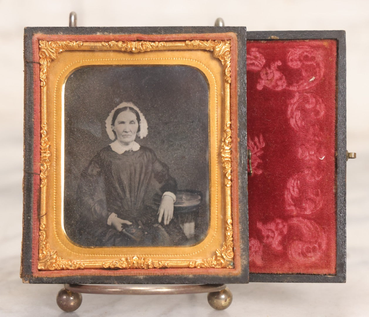 Lot 047 - Antique 1/6th Plate Ruby Ambrotype Photograph Of Elderly Woman In White Bonnet Holding Object, Possibly A Book, In Full Split Leatherette Union Case