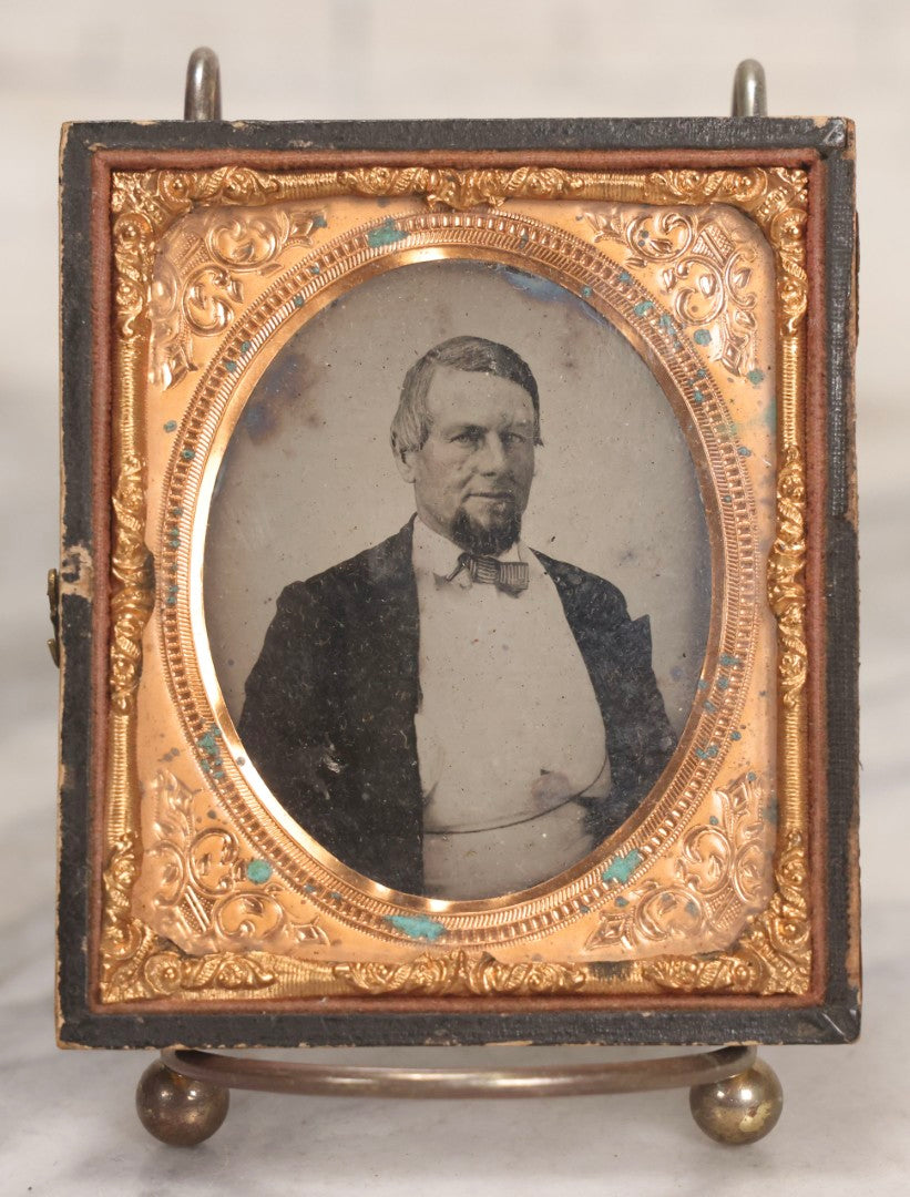 Lot 048 - Antique 1/6th Plate Ruby Ambrotype Photograph Of Skeptical-Looking Middle-Aged Man In Bowtie, White Shirt, And Blazer, In Half Leatherette Union Case