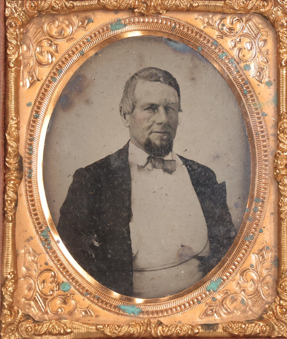 Lot 048 - Antique 1/6th Plate Ruby Ambrotype Photograph Of Skeptical-Looking Middle-Aged Man In Bowtie, White Shirt, And Blazer, In Half Leatherette Union Case