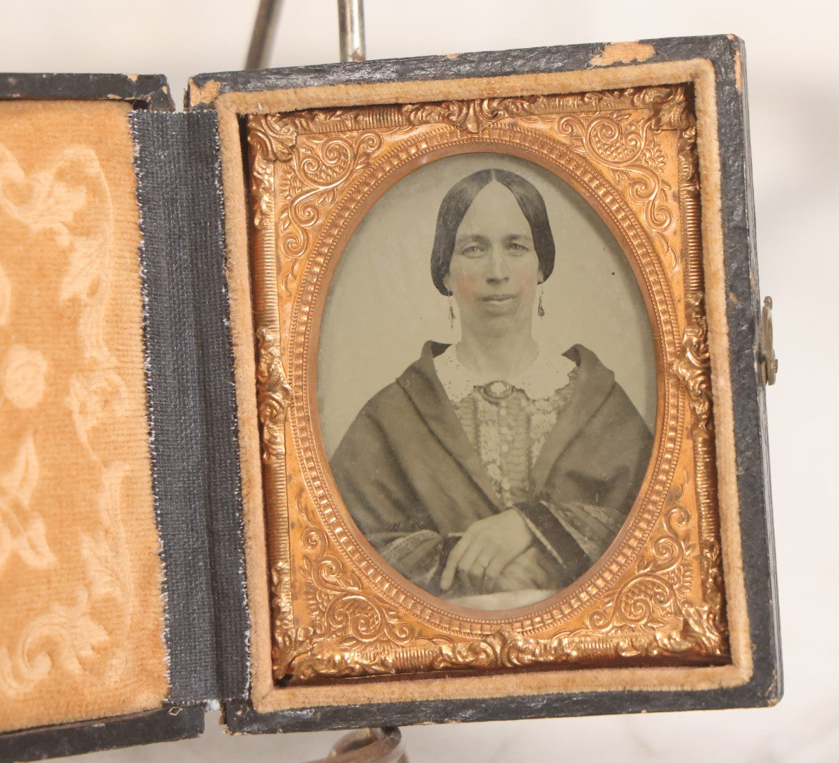 Lot 058 - Antique 1/9th Plate Hand-Tinted Ambrotype Photograph Of Woman With Shawl And Jewelry, In Full Leatherette Union Case Repaired With Taped Hinge