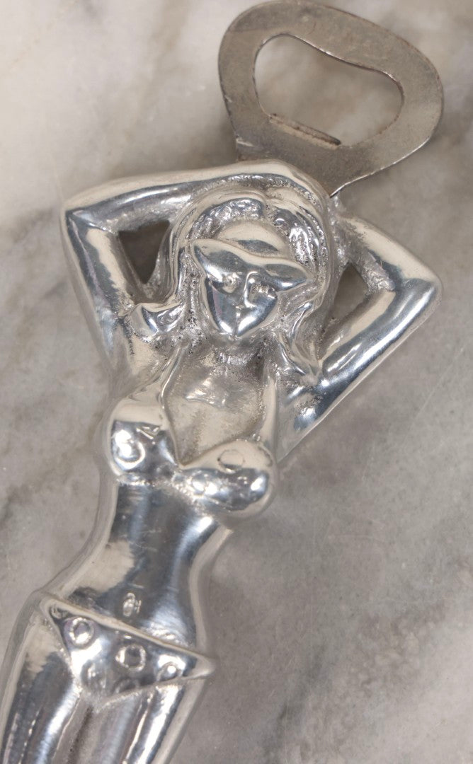 Lot 094 - Vintage Cast Aluminum Bikini Babe Bottle Opener, Woman With Sunglasses And Polka Dot Bikini, Circa 1980s 7-3/4" L
