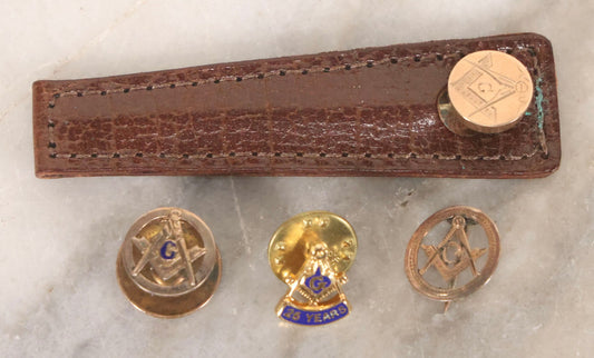 Lot 190 - Grouping Of Four Vintage Gold-Toned Masonic Pins With Compass And Square, Including Stick Pin In Leather Case And 25-Year Pin