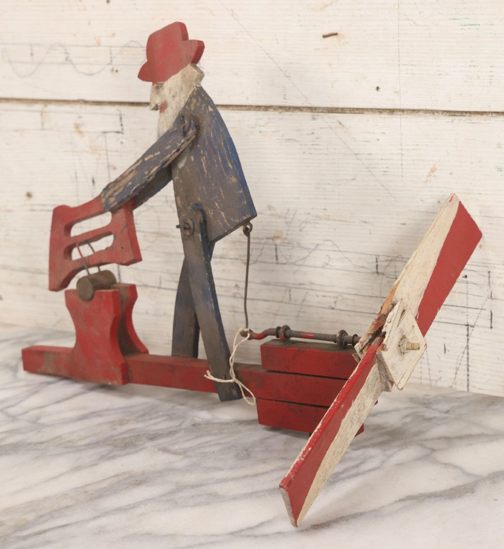 Lot 018 - Antique Hand Painted Wooden Folk Art Whirligig With Man Sawing Log, Missing Two Propeller Blades, 15-1/4" L