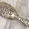 Lot 053 - Antique Art Deco Metal Clad Dresser Brush With Stylized Radiating Oval Motif, 9" L