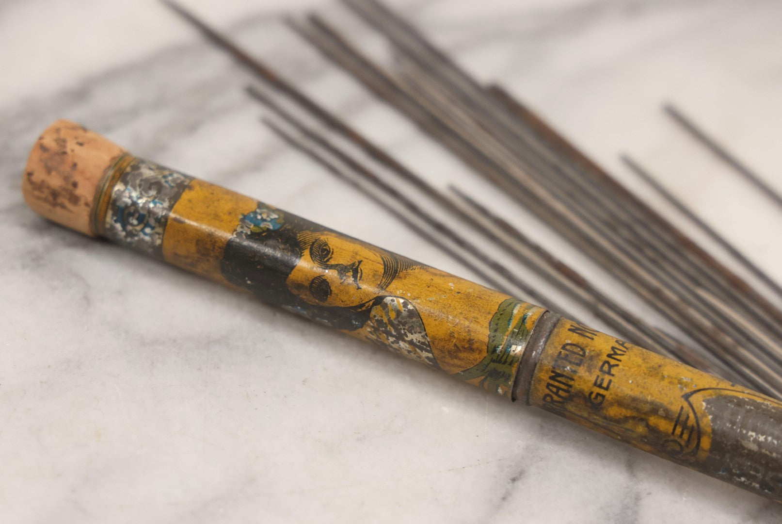 Lot 054 - Antique Gloria Brand Highly Tempered Steel Knitting Pins In Original Tin Lithograph Tube With Woman's Face Motif, Made In Germany, 9-3/4" L