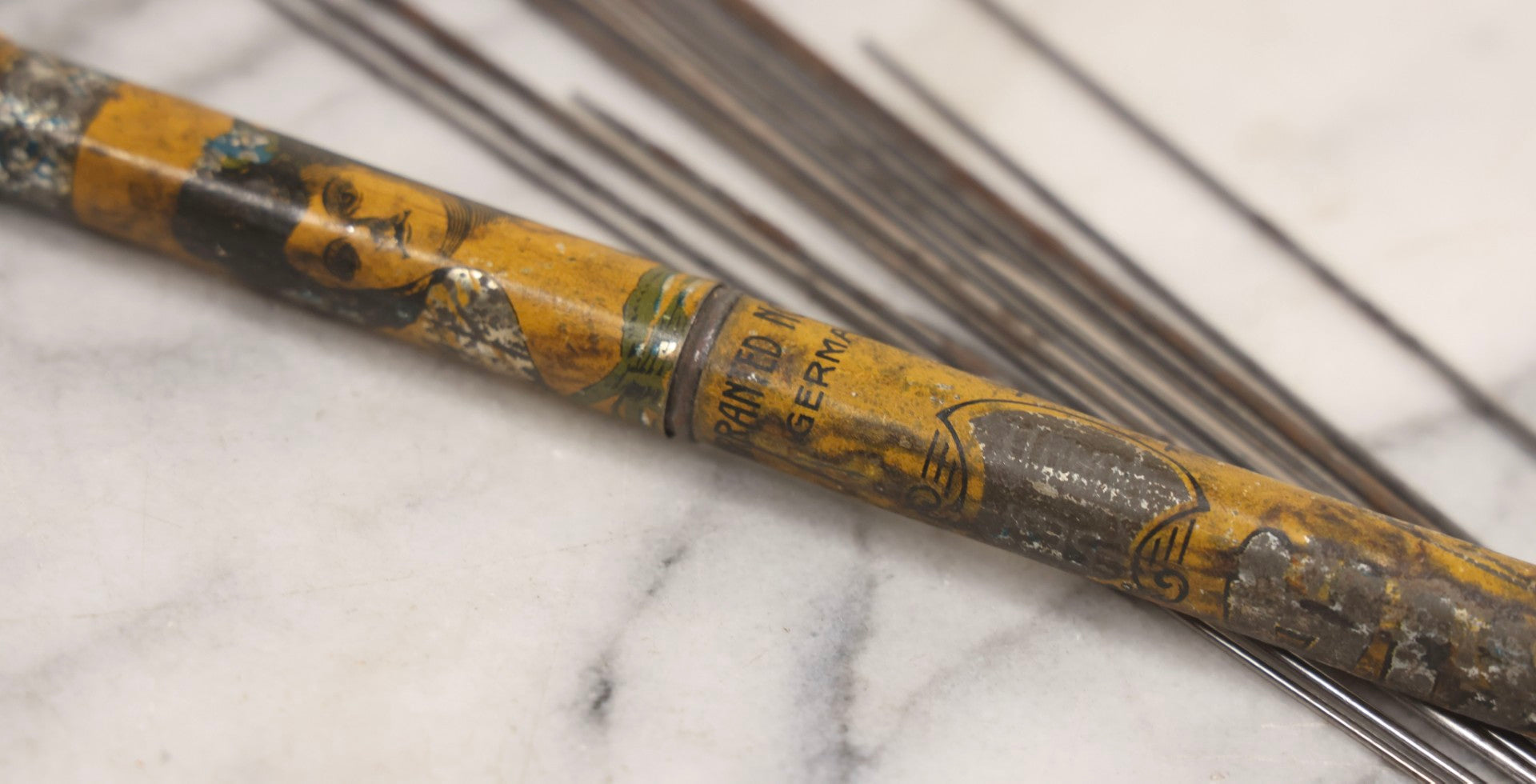 Lot 054 - Antique Gloria Brand Highly Tempered Steel Knitting Pins In Original Tin Lithograph Tube With Woman's Face Motif, Made In Germany, 9-3/4" L