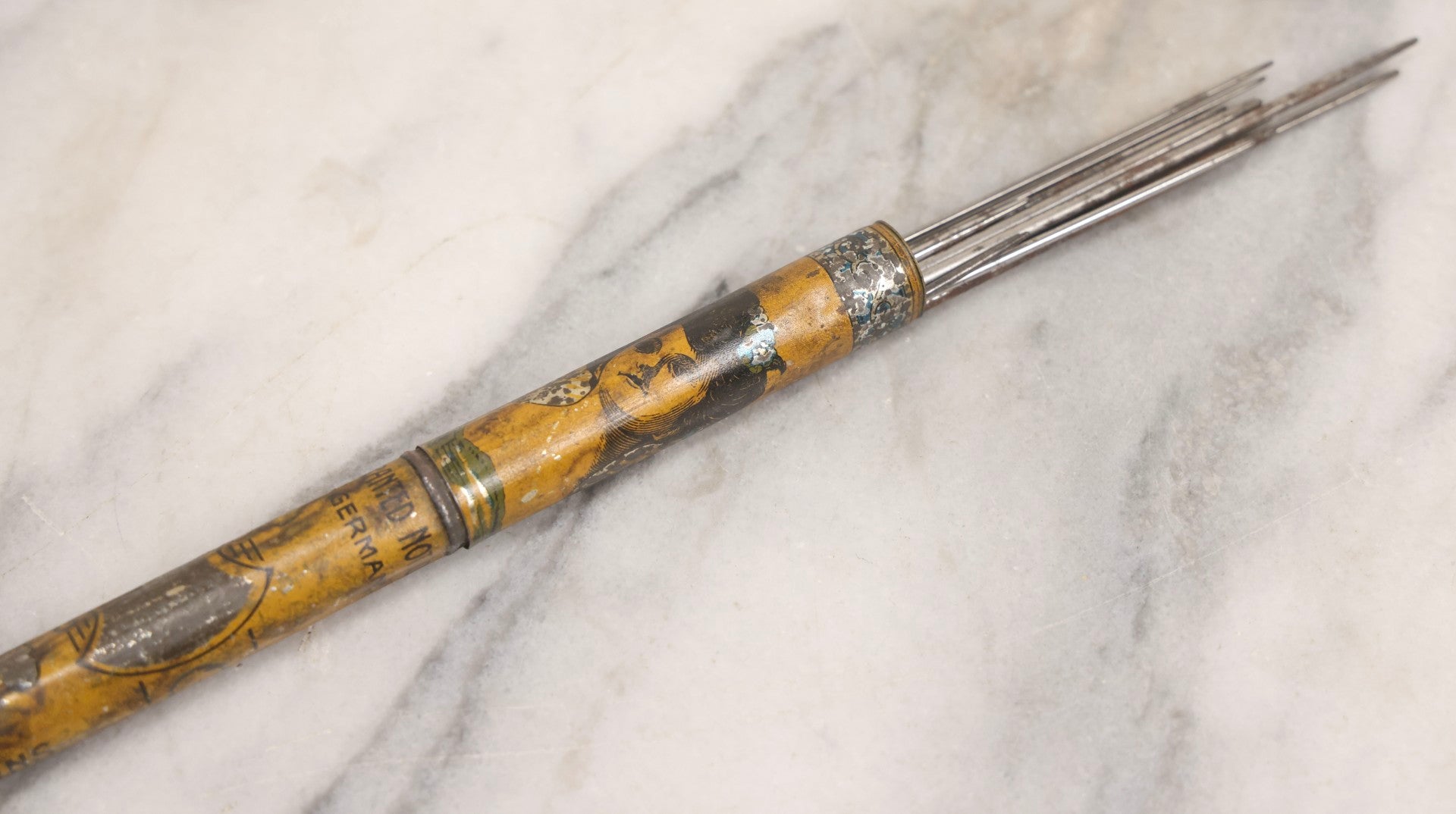 Lot 054 - Antique Gloria Brand Highly Tempered Steel Knitting Pins In Original Tin Lithograph Tube With Woman's Face Motif, Made In Germany, 9-3/4" L