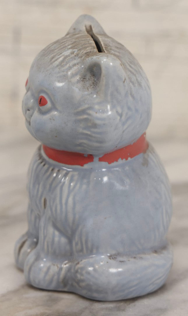 Lot 075 - Vintage Porcelain Hubley-Style Cat Still Bank With Blue Body, Red Eyes, And Red Bow, Note Damage, 4-1/2" H