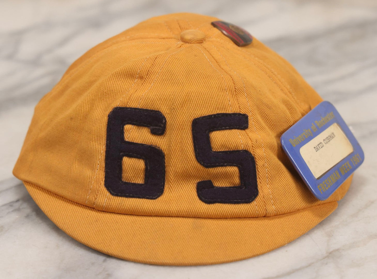 Lot 085 - Vintage Orange Cap With “65” Patch, E. Rosenstein Sons Label, And Two University Pins