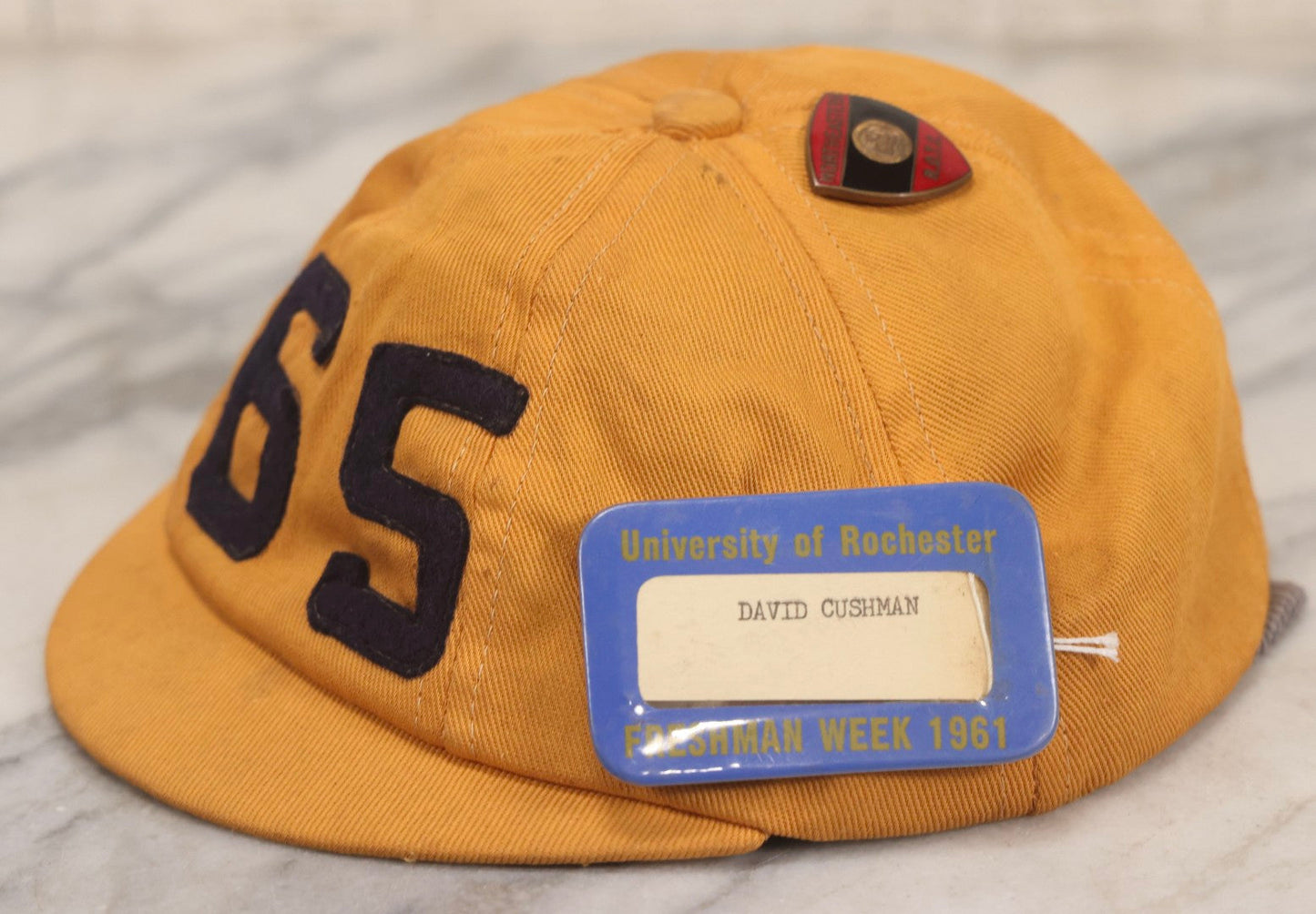 Lot 085 - Vintage Orange Cap With “65” Patch, E. Rosenstein Sons Label, And Two University Pins