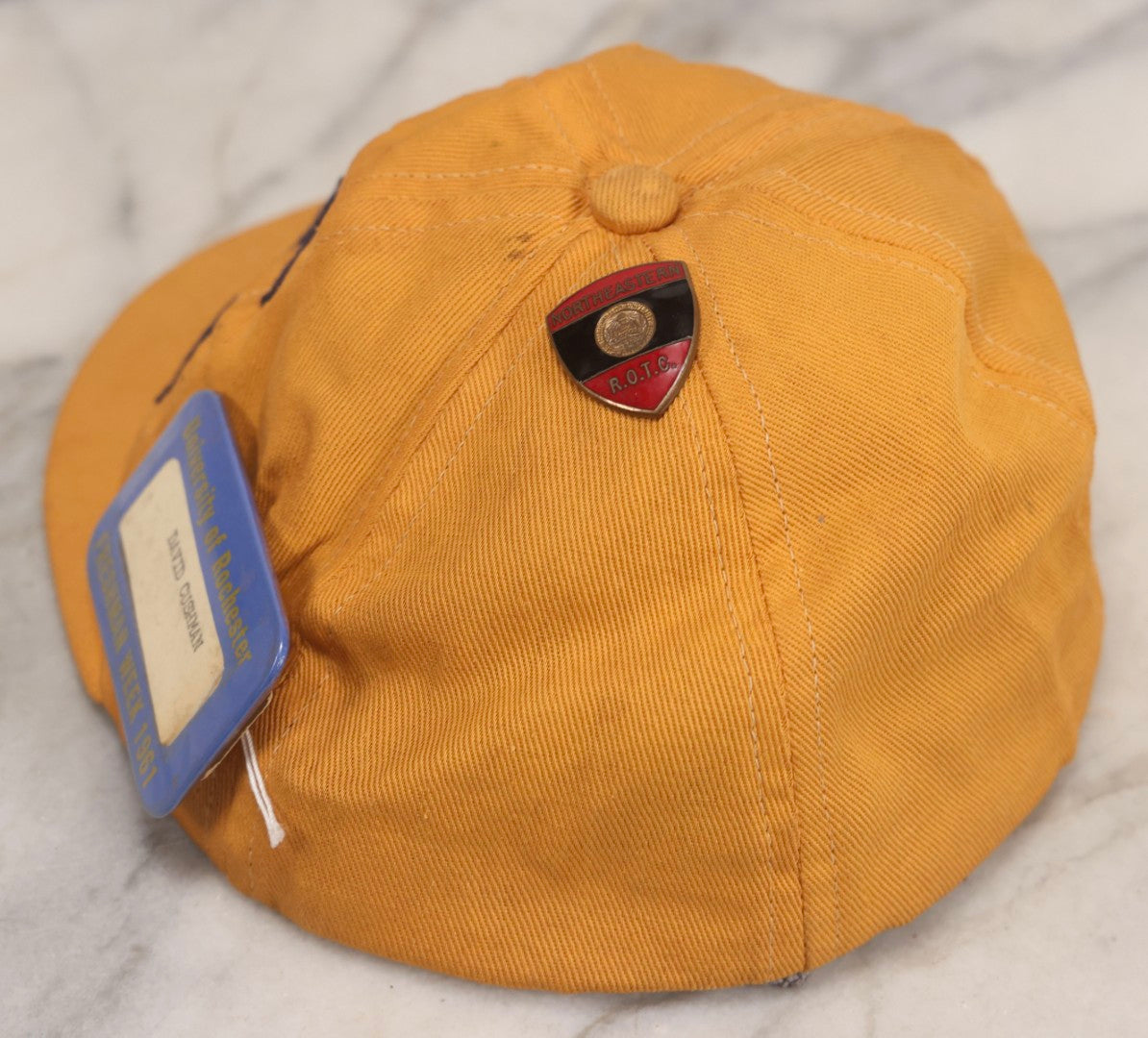 Lot 085 - Vintage Orange Cap With “65” Patch, E. Rosenstein Sons Label, And Two University Pins