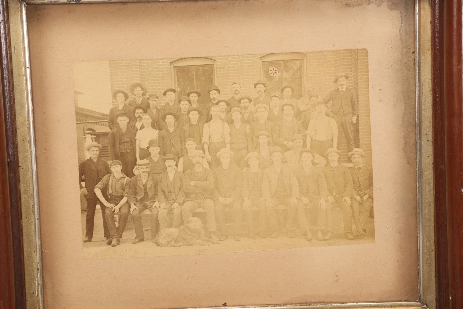 Lot 137 - Antique Occupational Boarded Photograph Of Factory Workers With Dog In Deep Walnut Frame, Circa 1880–1890, 13-1/2" x 11-1/2"
