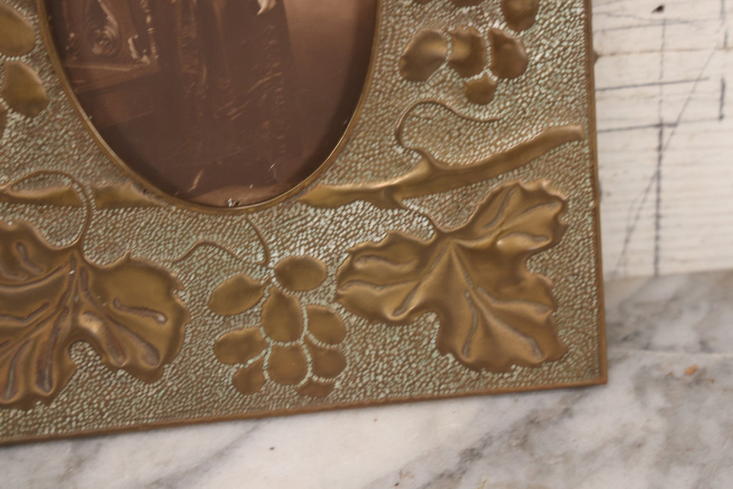 Lot 138 - Antique Hammered Brass Photo Frame With Grapes And Grape Leaves Motif, Missing Stand, 8-1/8" x 10"