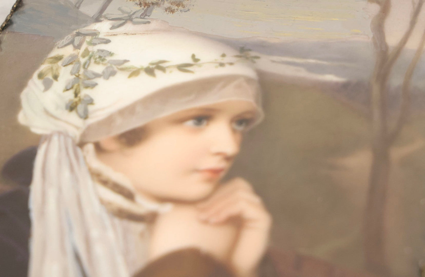 Lot 012 - Antique Painted Porcelain Tile Of Young Praying Woman In Brass Frame With Crest, Note Large Diagonal Crack Through Tile And Multiple Cracks From Upper Left Corner Damage, 4-7/8" x 9-1/8"