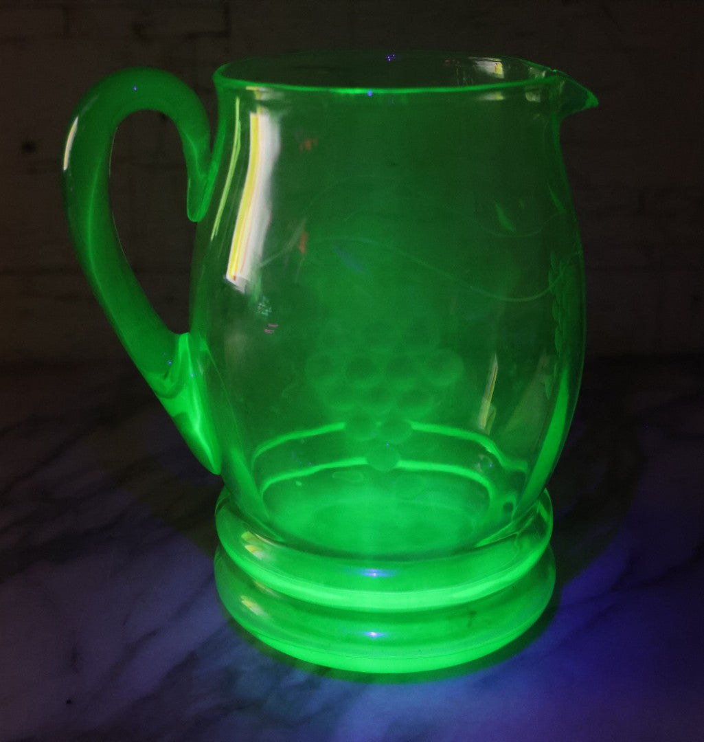 Lot 022 - Antique Uranium Glass Pitcher With Etched Grape Motif, Glows Under Blacklight, Note Chip On Spout