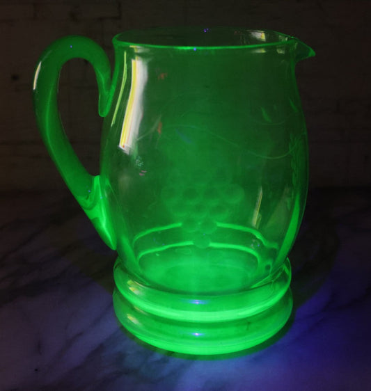 Lot 022 - Antique Uranium Glass Pitcher With Etched Grape Motif, Glows Under Blacklight, Note Chip On Spout