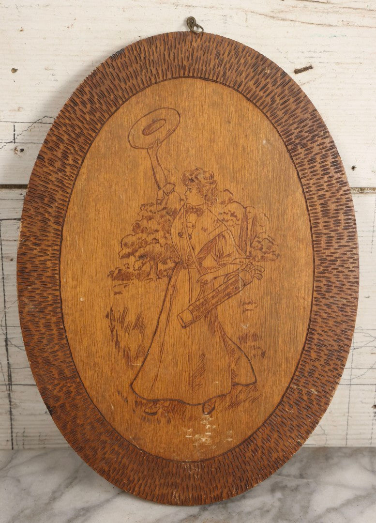 Lot 043 - Antique Pyrography Wood Plaque Depicting Gibson Girl Golfer, Period Dress, Hat Raised In The Air, With Decorative Border Design, 9-3/4" x 10-1/2"