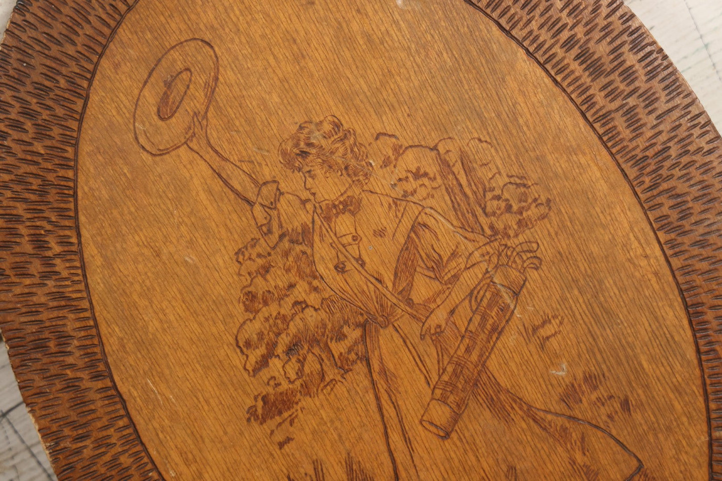 Lot 043 - Antique Pyrography Wood Plaque Depicting Gibson Girl Golfer, Period Dress, Hat Raised In The Air, With Decorative Border Design, 9-3/4" x 10-1/2"