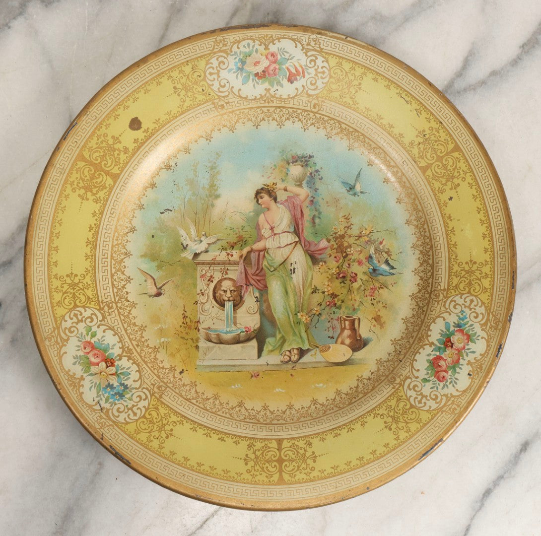 Lot 049 - Antique Vienna Art Plates Tin Lithograph Decorative Plate With Classical Maiden, Birds, And Floral Motifs, Marked “Vienna Art Plates, Patent Applied For”