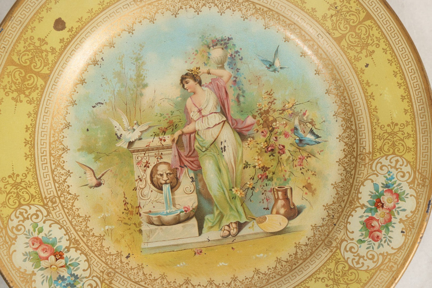 Lot 049 - Antique Vienna Art Plates Tin Lithograph Decorative Plate With Classical Maiden, Birds, And Floral Motifs, Marked “Vienna Art Plates, Patent Applied For”