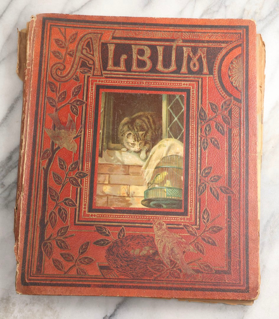 Lot 077 - Antique Red Scrapbook Album With Cat And Birdcage Illustration On Cover, 40+ Pasted Scraps, Victorian Trade Cards, Die Cuts, Loose Ephemera, Rena B. Coggeshalt Name Card, Circa 1875
