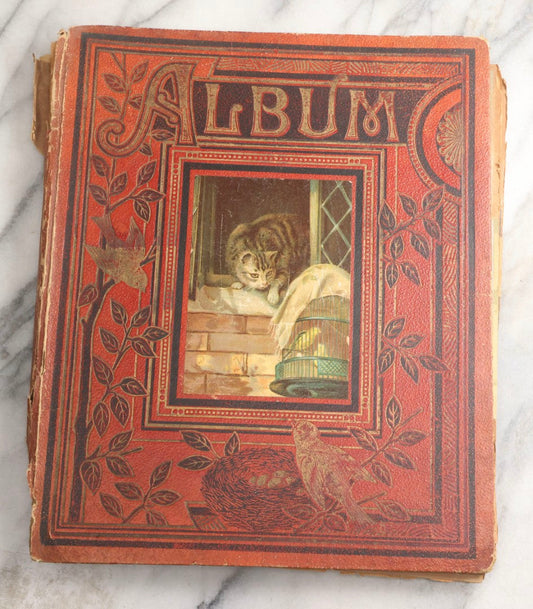 Lot 077 - Antique Red Scrapbook Album With Cat And Birdcage Illustration On Cover, 40+ Pasted Scraps, Victorian Trade Cards, Die Cuts, Loose Ephemera, Rena B. Coggeshalt Name Card, Circa 1875
