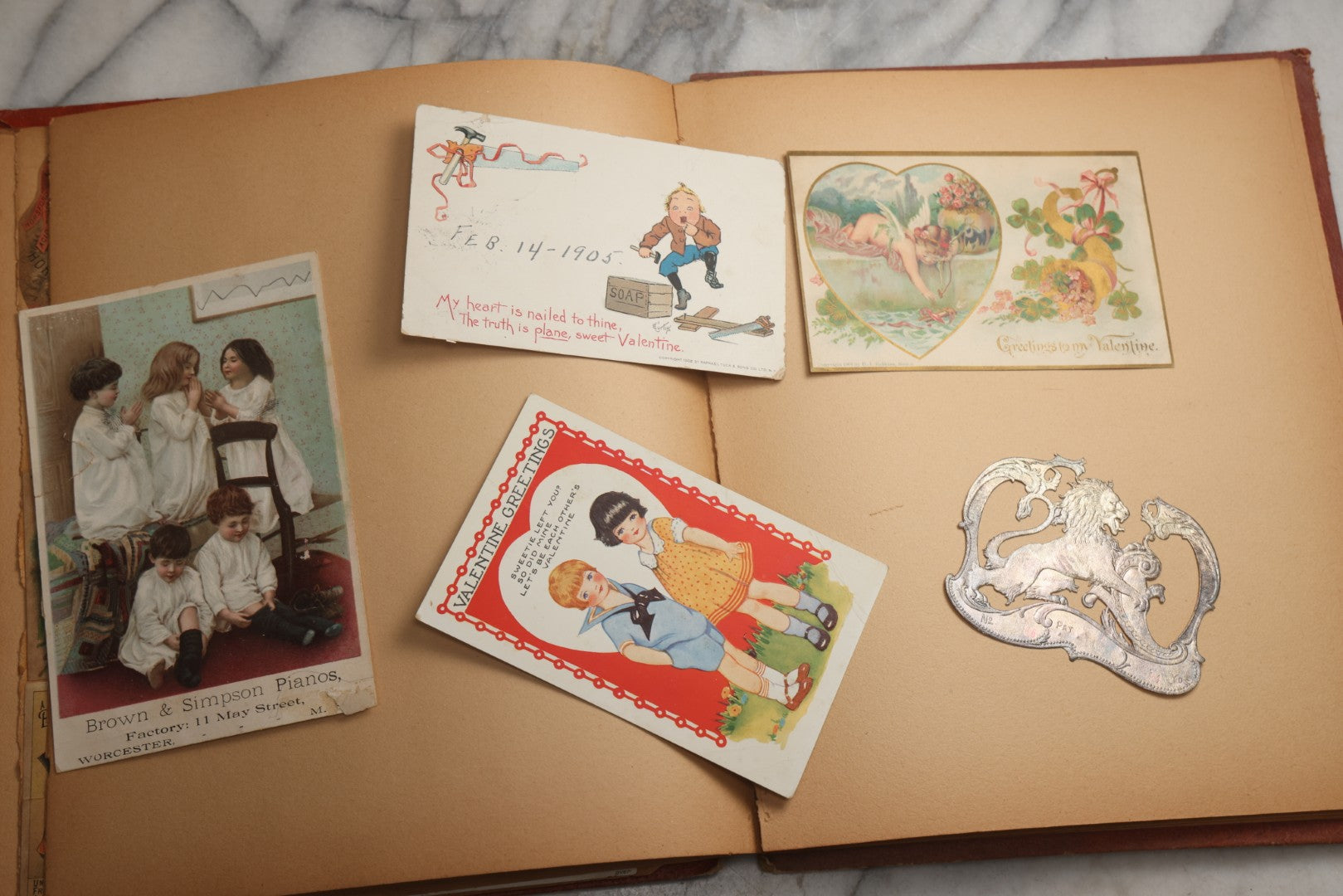 Lot 077 - Antique Red Scrapbook Album With Cat And Birdcage Illustration On Cover, 40+ Pasted Scraps, Victorian Trade Cards, Die Cuts, Loose Ephemera, Rena B. Coggeshalt Name Card, Circa 1875