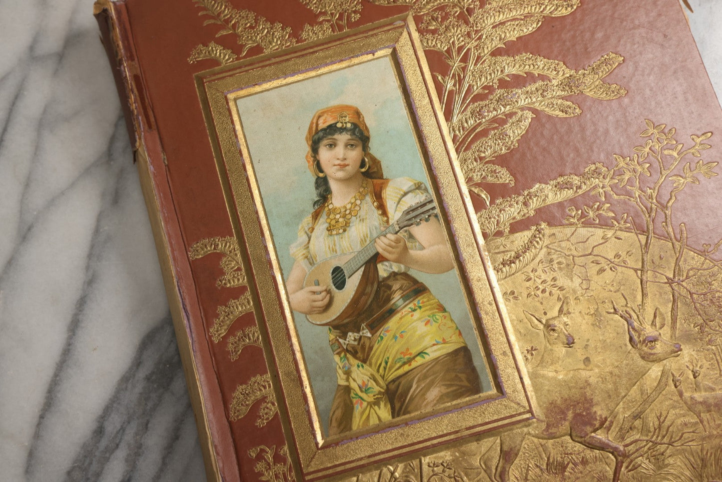 Lot 078 - Antique Scrapbook Album With Gold Embossed Deer In Forest And Pasted Gypsy Woman Chromolithograph On Cover, 150+ Victorian Trade Cards, Die Cuts, Children, Pets And Women's Fashion, Circa 1898