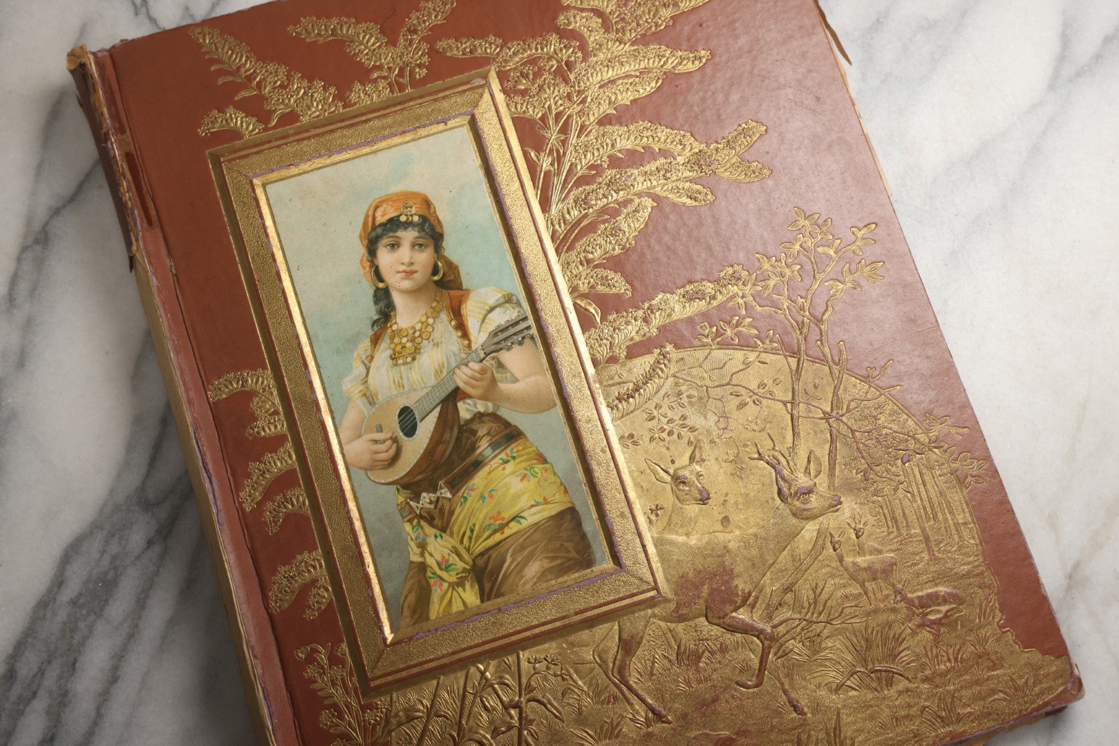 Lot 078 - Antique Scrapbook Album With Gold Embossed Deer In Forest And Pasted Gypsy Woman Chromolithograph On Cover, 150+ Victorian Trade Cards, Die Cuts, Children, Pets And Women's Fashion, Circa 1898