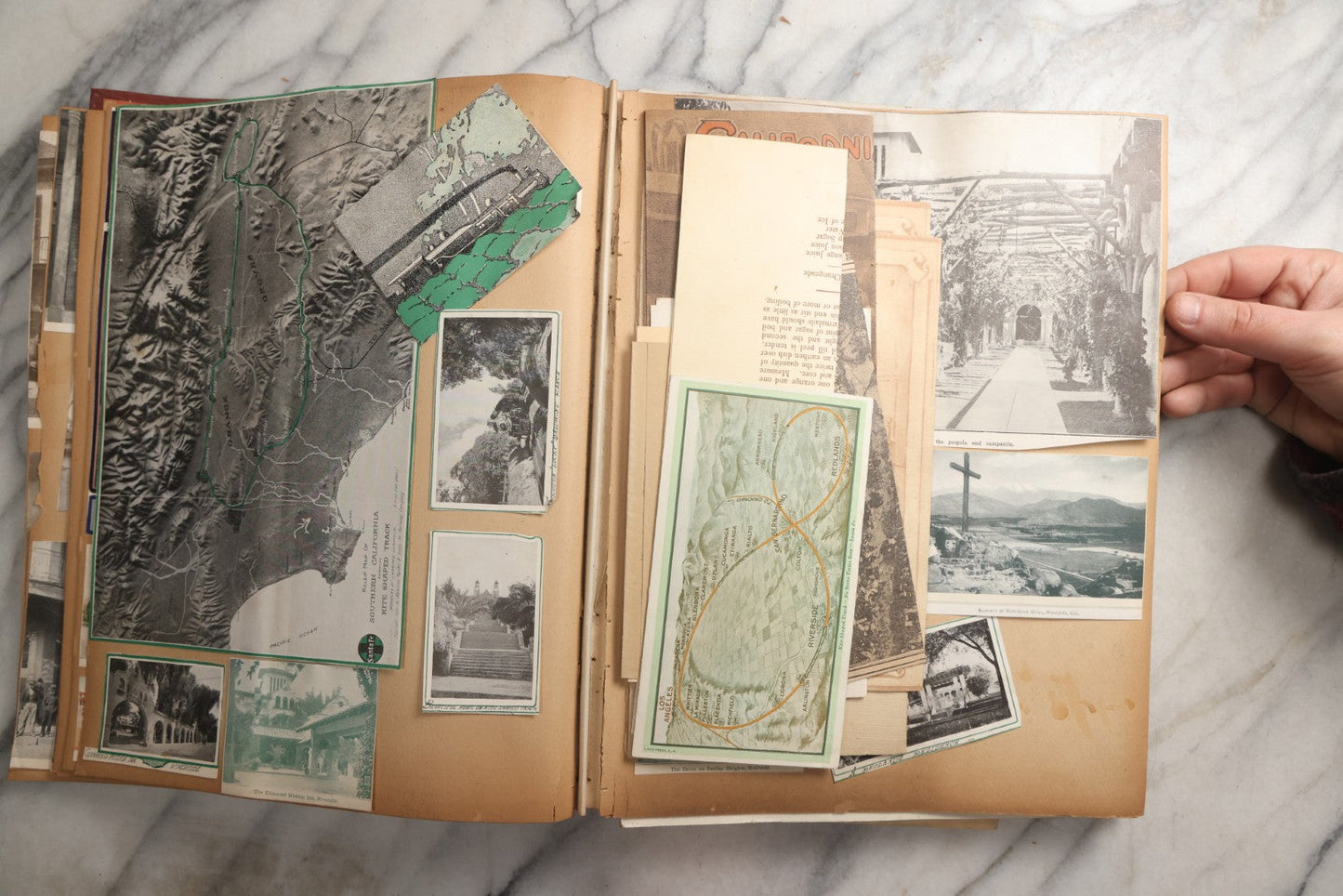 Lot 087 - Antique "The Nonpareil" Scrapbook Album With New Orleans, California, Arizona Ephemera, Pressed Flowers, 1914 Raja-Yoga Messenger Magazine, Patent March 1876, Heavy Water Staining, Warped Boards, Brittle Binding And Pages, Circa 1914