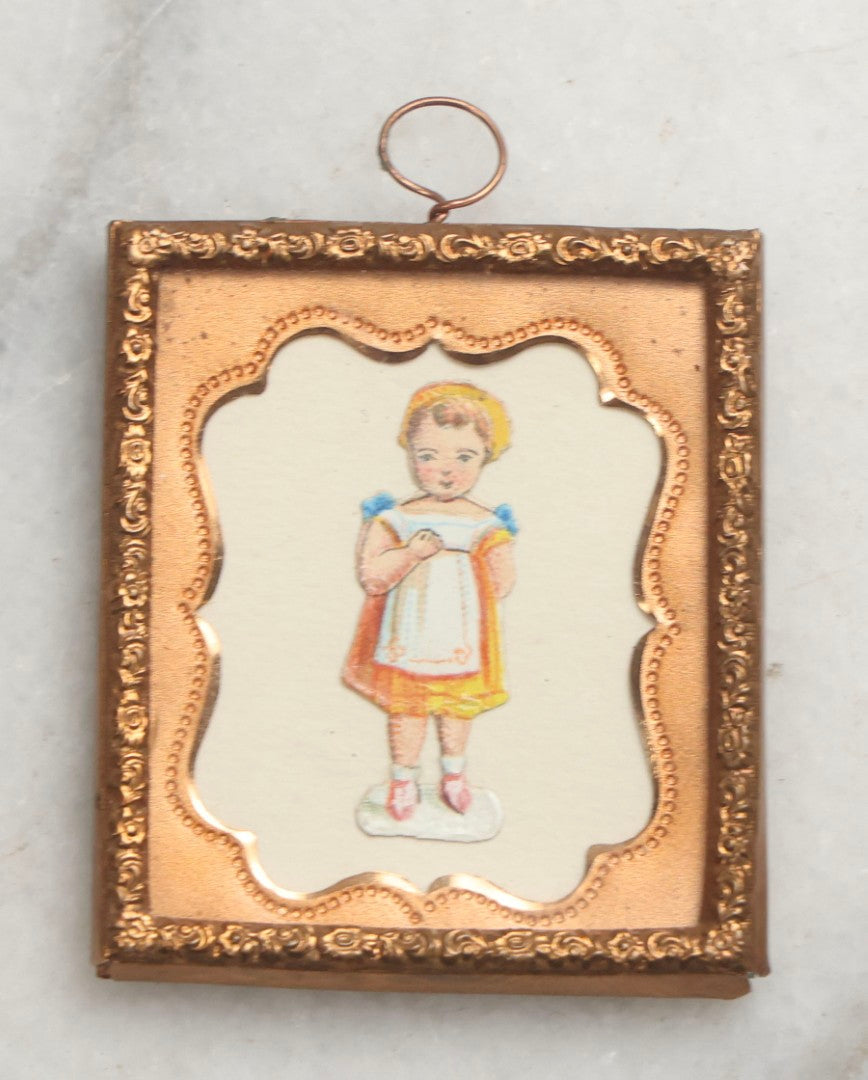 Lot 098 - Trio Of Antique Miniature Die-Cut Chromolithograph Scrap Figures In 1/9th And 1/16th Plate Photo Frames, Including Girl With Muff & Boy With Scythe, Boy With Sword, And Girl In Yellow Dress, All With Backing And Wire Loops