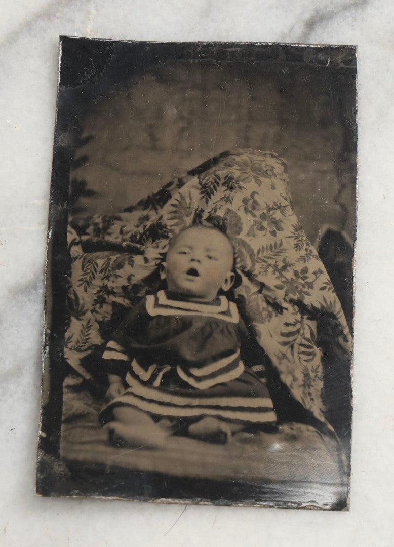 Lot 105 - Antique Hidden Mother Tintype Photograph Of Baby With Mouth Agape, Seated With Mother Or Assistant Conspicuously Concealed Beneath Floral Blanket Behind Baby